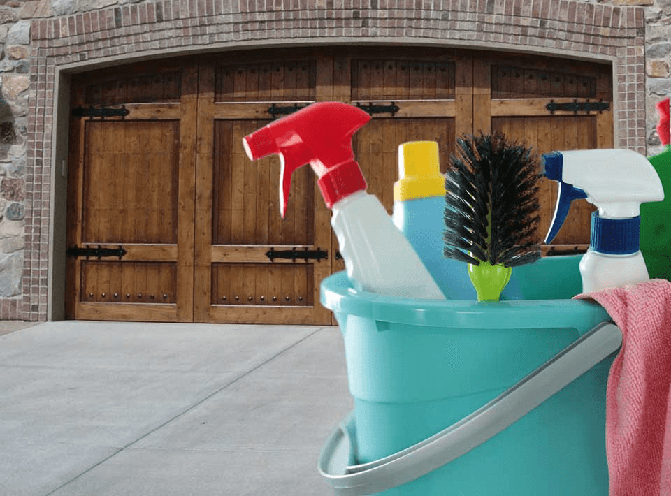 Wooden garage door with cleaning supplies in a teal bucket